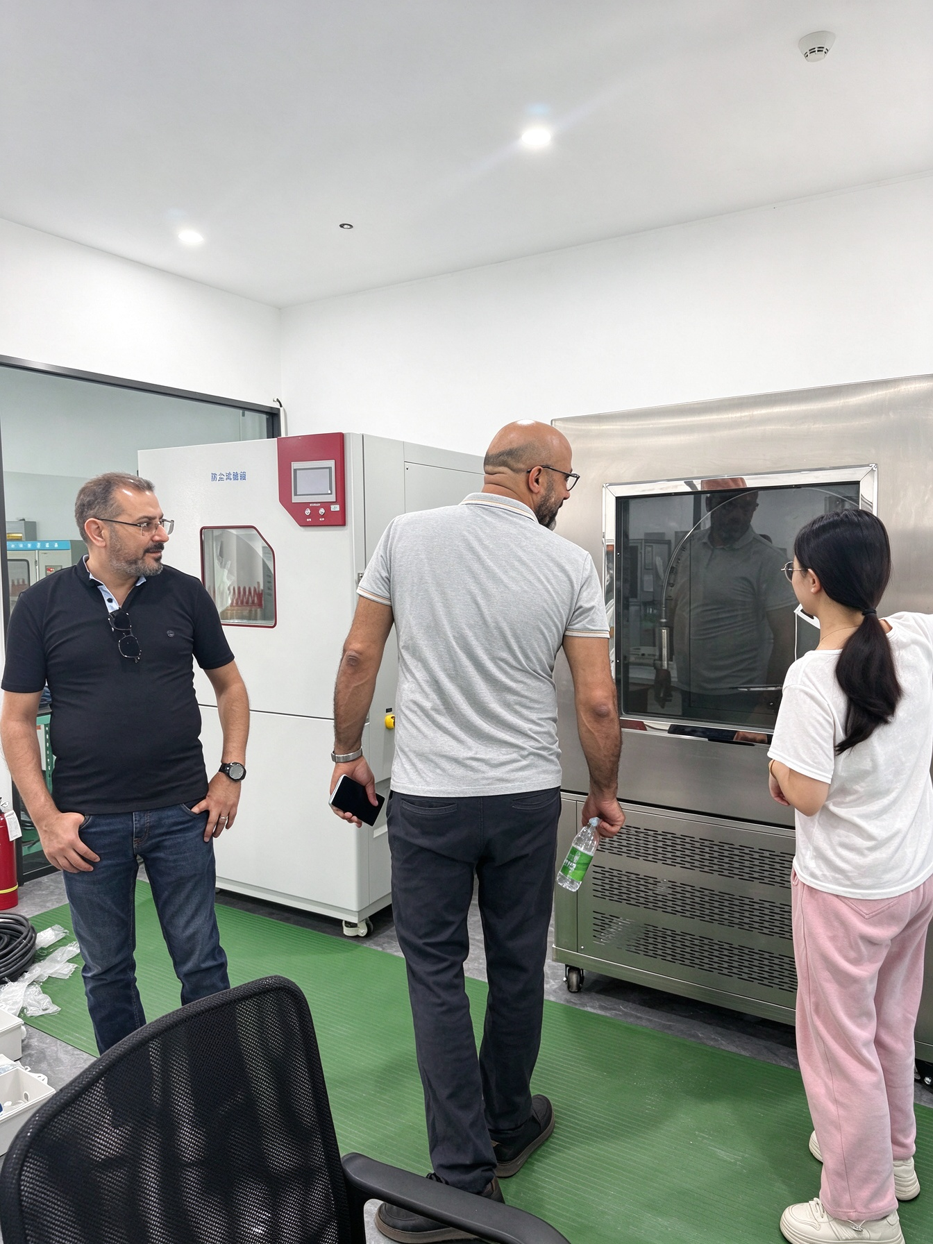junwei-tunisian-clients-testing-laboratory-tour Tunisian clients viewing testing equipment with a Junwei Electric representative in the laboratory